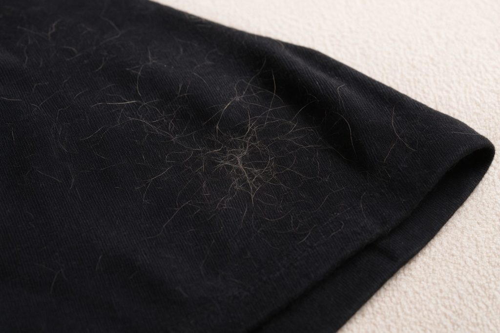 黒い服に猫の毛がたくさんついている写真。ペットの抜け毛の悩みを解消する衣類用液体洗剤リモサボン。